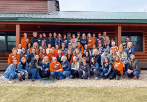 A group in front of a cabin at Cedar Valley Resort